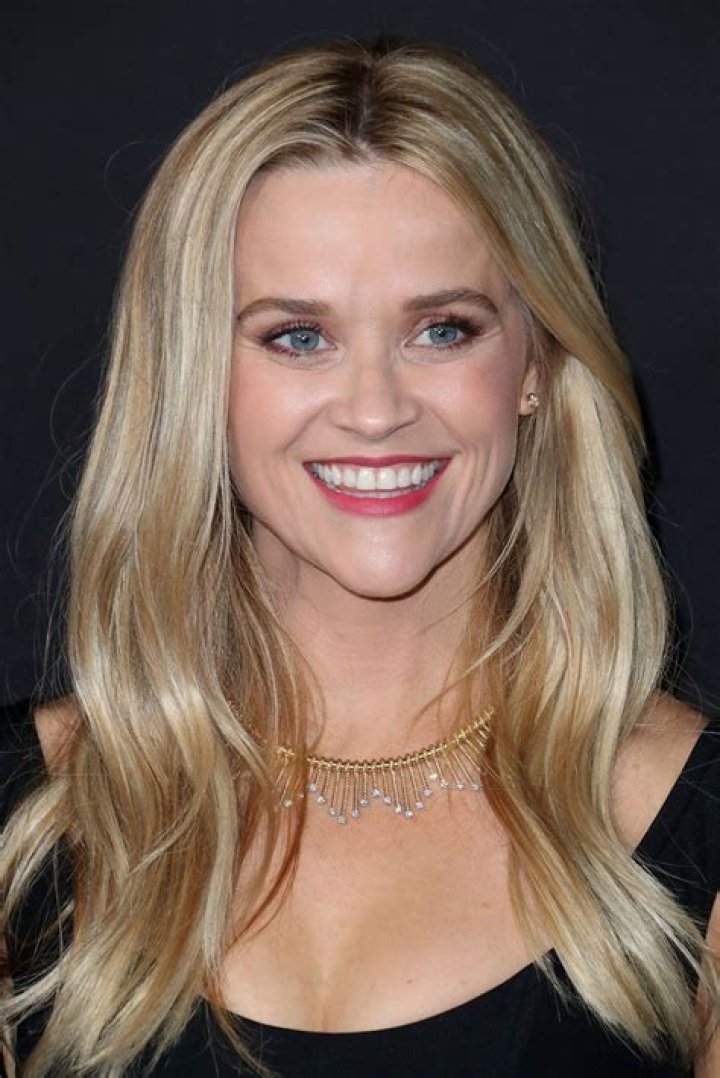 Reese Witherspoon beams eartoear in a denim skirt as she films Your